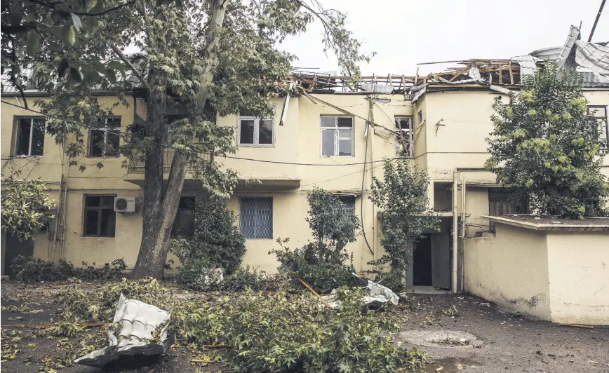  ??  ?? A view of a building and trees damaged by Armenian shelling against civilians, in the Azerbaijan­i district of Tartar, Oct. 7, 2020.