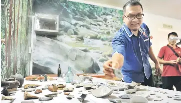  ??  ?? Mohd Shermann showing the artifacts discovered from the constructi­on site in Kuching yesterday. — Bernama photo