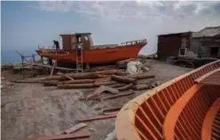  ?? Associated Press ?? Boatbuilde­rs work at a boatyard in Karlovasi , Samos Island , Greece.