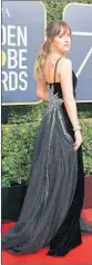  ?? VALERIE MACON/GETTY ?? Dakota Johnson in a black organza and velvet gown with a crystal buckle and crystal embroidere­d train.
