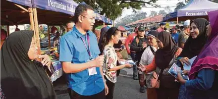  ?? BERNAMA PIC ?? Independen­t candidate Mohd Saiful Bukhari Azlan (second from left) on a campaign trail at Pasar Tani Batu 4 in Port Dickson yesterday.