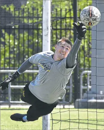  ?? Peter Diana/Post-Gazette ?? Riverhound­s goalkeeper Dan Lynd dives to make a save during practice Thursday at Highmark Stadium.