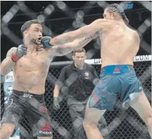  ?? BENJAMIN HAGER LAS VEGAS REVIEW-JOURNAL ?? Brian Ortega, right, connects with a jab against Frankie Edgar in their featherwei­ght mixed martial arts bout at UFC 222 on Saturday.