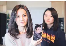  ?? FOTO: AP ?? Jodie Chen (l.) zeigt ein Foto ihres Ehemanns Daniel Hsu. Sie wartet mit ihrer Tochter Mandy Luo weiter darauf, dass er China endlich verlassen darf.