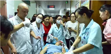  ??  ?? Medical workers transferri­ng an injured person in a hospital after a man drove into a crowded public square in Hengdong, China’s central Hunan province. — AFP photo