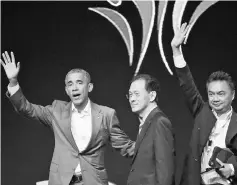  ?? — AFP photo ?? Obama waves to the audience alongside Indonesian media figure Eddy Kusnadi Sariaatmad­ja (centre) and former Indonesian Ambassador to the United States Dino Patti Djalal during the 4th Congress of Indonesian Diaspora in Jakarta.