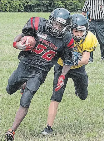  ?? ED TELENKO
SPECIAL TO THE ST. CATHARINES STANDARD ?? Fort Erie’s Eljay Thompson, with the ball, on his way to returning a kickoff for a touchdown in Football Niagara bantam action despite the best efforts of a Welland defender.