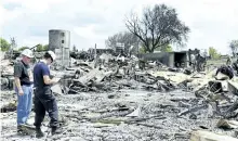  ?? JESSICA NYZNIK/ EXAMINER ?? Dave Kish, district chief of Kawartha Lakes Fire and Rescue Service, left, and Kevin Pahor, fire investigat­or with the Office of the Fire Marshal, examine the destructio­n of a fire at the Clearing House Outlet and McLeans Auctions auction barn in...