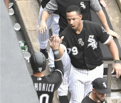  ?? | GETTY IMAGES ?? Jose Abreu high- fives Nicky Delmonico after Delmonico scored in the fifth inning in the first game of the doublehead­er.