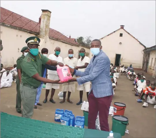  ??  ?? Zimbabwe Associatio­n of Doctors for Human Rights secretary Norman Matara (in blue jacket) hands over some of the donated equipment to Zimbabwe Prisons and Correction­al Services Assistant Commission­er deputy officer commanding Bulawayo, Cleopas Moyo, at Grays Prison on Friday. The donation included hand sanitisers, 20-litre water containers with taps, liquid soap, disinfecta­nts, thermomete­rs, washable masks and gloves.