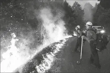  ?? AP PHOTO/NIC COURY ?? Firefighte­rs monitor a controlled burn along Nacimiento-Fergusson Road to help contain the Dolan Fire near Big Sur, Calif., on Sept. 11, 2020.