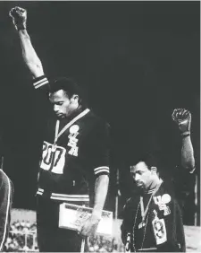  ?? OFF/AFP/GETTY IMAGES ?? Tommie Smith, left, and John Carlos of the U.S. give the Black Power salute after receiving their medals for first and third place in the men’s 200m event at the 1968 Mexico Olympic Games