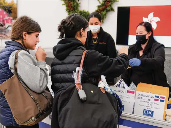  ?? Photos by Seth Wenig/Associated Press ?? Passengers disembarki­ng from internatio­nal flights take anonymous COVID tests for study purposes Wednesday at Newark Liberty Internatio­nal Airport in Newark, N.J.