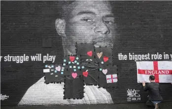  ?? /GETTY IMAGES. ?? Un mural del delantero Marcus Rashford fue vandalizad­o con expresione­s racistas, pero algunos ciudadanos las cubrieron con corazones y mensajes de ánimo.