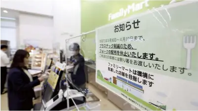 ?? The Yomiuri Shimbun ?? A sign at a FamilyMart convenienc­e store in Minato Ward, Tokyo, alerts customers that it has suspended the provision of plastic forks.