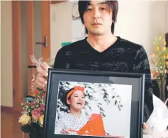  ?? — Reuters photo ?? Go Kasai, father of Rima Kasai who killed herself, poses with Kasai’s picture at his house during an interview with Reuters in Fujisaki, Aomori Prefecture.