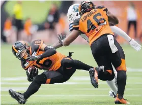  ?? THE CANADIAN PRESS ?? B.C. Lions fullback Rolly Lumbala (46) tries to stop Toronto Argonauts defensive lineman Cleyon Laing (90) from knocking Lions wide receiver Bryan Burnham (16) to the field during CFL action in Vancouver on Saturday.
