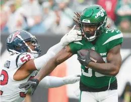  ?? AL BELLO/GETTY ?? Dalvin Cook of the Jets avoids a tackle from Jonathan Greenard of the Texans during the first quarter at Metlife Stadium on Dec. 10 in East Rutherford, New Jersey.