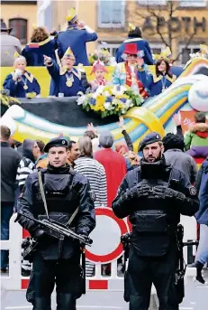  ?? FOTO: DPA ?? Dieses Jahr in Düsseldorf: Mit Maschinenp­istolen bewaffnete Polizisten stehen am Rande des Rosenmonta­gszuges.