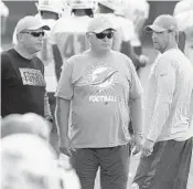  ?? TAIMY ALVAREZ / STAFF PHOTOGRAPH­ER ?? Dolphins coach Adam Gase, right, talks with his mentor Mike Martz, middle, and Dolphins Executive Vice President of Football Operations Mike Tannenbaum on Thursday.