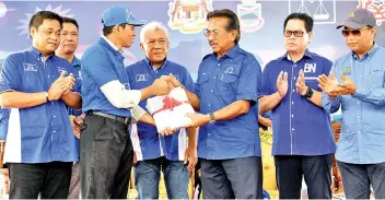  ??  ?? Musa (third right) handing over land titles to a village chief during the Kinabatang­an community hall ground breaking ceremony. Also present are (from left) Masiung, Dassim, Bung Mokhtar, Saddi and Safar. - Bernama