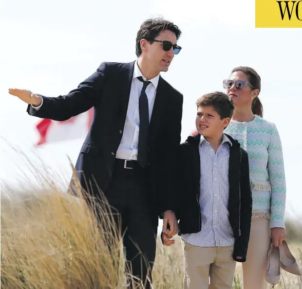  ?? CHARLY TRIBALLEAU / AFP / GETTY IMAGES ?? Prime Minister Justin Trudeau speaks to his wife Sophie Gregoire and son Xavier as they walk along Juno Beach in Courseulle­s-sur-Mer, France. The prime minister told a news conference during the visit that the way forward in Syria can’t include...