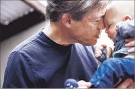 ?? Jay L. Clendenin Los Angeles Times ?? BERGGRUEN cuddles his son, Alexander. Alexander and his sister, Olympia, were born from one egg-donor and two surrogates.