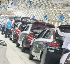  ?? SOMCHAI POOMLARD ?? Workers inspect passenger cars at a production line of an automotive manufactur­ing plant in Laem Chabang Industrial Estate.