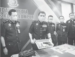  ?? — Gambar Bernama ?? TUMPAS: Azmi (dua kiri) ketika sidang media di Ibu Pejabat Kontinjen Kuala Lumpur semalam.