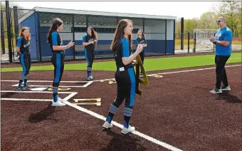  ?? DANA JENSEN/THE DAY ?? Waterford softball coach Andy Walker, right, poses his seniors for a photograph on the new softball field last month. The five seniors never got to play a game on their new turf field after the spring sports season was canceled due to the COVID-19 pandemic. The five were part of the Lancers’ state title team in 2019.