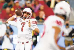  ?? DENIS POROY GETTY IMAGES ?? Utah quarterbac­k Cameron Rising looks for a receiver in the first half against USC. Rising threw three touchdowns in a victory by the Utes.