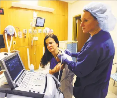  ?? Michael Cummo / Hearst Connecticu­t Media ?? Dr. Betty Ann Robustelli, center, and Dr. Juliet Jackson use an ultrasound machine inside Stamford Hospital on Jan. 16. The machine helps anesthesio­logists deliver numbing agents more efficientl­y and safely.