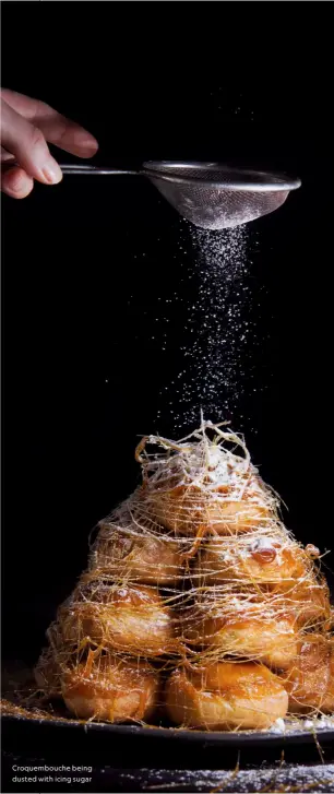  ?? ?? Croquembou­che being dusted with icing sugar