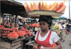  ?? PHOTO: AP ?? A woman sells skinned pawpaw, papaya, as she walks in a market in Lagos, Nigeria. The country’s inflation was little changed as food prices rose 0.8 percent in September.