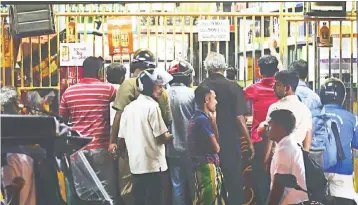  ??  ?? Sri Lankan customers buy alcoholic drinks from a liquor shop in Colombo. Sri Lanka sharply raised taxes on alcohol, tobacco and gambling to pay for public sector salary increases and subsidised loans for small businesses in an election year. — AFP photo