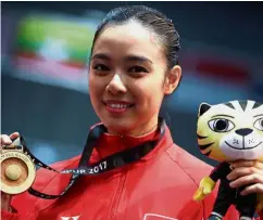  ??  ?? Don’t mess with this girl: Indonesia’s wushu exponent
Lindswell Kwok posing with her gold in the women’s taijiquan.