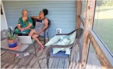  ?? AP PHOTO/SARAH BLAKE MORGAN ?? Ruby Penn, left, and her sister, Penny Blue, sit on the porch of their Franklin County, Va., home. Penn, who frequently drives past a Confederat­e flag near her home, said living in Franklin County means living under constant symbols of racism that still exist there.