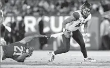  ?? Photograph­s by Robert Gauthier
Los Angeles Times ?? ARIZONA QUARTERBAC­K Anu Solomon runs away from USC’s Su’a Cravens, who can grab only Solomon’s towel.