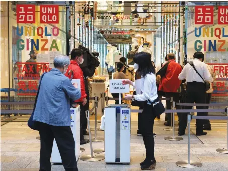  ??  ?? Customers wait in a queue outside a Uniqlo store in Tokyo’s Ginza shopping district. Same-store sales are up 26 percent from June 2019.