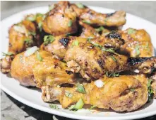  ?? TNS ?? Maple-sriracha chicken drumsticks can be cooked over a charcoal or gas grill. Recipe, page C3.