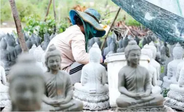  ?? HONG MENEA ?? A volunteer paints a statue of a mediating Buddha that will eventually grace the hill on the grounds of the pagoda in Trapaing Kro Nhoung commune.