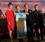  ?? CHANG JUN / CHINA DAILY ?? Nell Calloway (second from left), granddaugh­ter of founder of the Flying Tigers, General Claire Lee Chennault, receives a banner on Saturday in Los Angeles at the opening ceremony of a display wall.