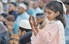  ?? ?? Una niña paquistaní realiza la oración de Eid al-Fitr en Karachi. A la derecha, un jinete participa en el festival Durbar, un festival cultural, religioso y ecuestre del antiguo Reino Hausa, que coincide con Eid al Fitr, en Ilorin