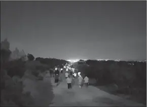  ?? HERALD photo/jordan Parr ?? Left: Coordinato­r Craig Felty gives last minute directions and encouragem­ent to the Moonlight runners at the starting line at the top of Scenic Mountain on Friday night. Right: Moonlight Runners take the trail by storm and head off into the lights of Big Spring. By JORDAN PARR