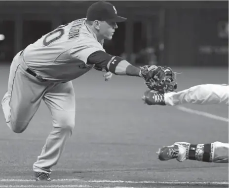  ?? COLE BURSTON/TORONTO STAR ?? Seattle’s Logan Morrison tags the ankle of Toronto’s Kevin Pillar during the ninth inning Friday. Pillar was initially ruled safe, then called out on review.