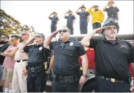  ??  ?? SANTA PAULA officials, police officers and firefighte­rs salute from a bridge as Iverson’s motorcade passes. He is survived by his expectant wife and a daughter, 2.