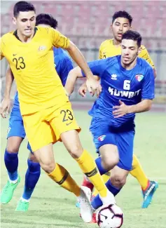  ??  ?? Tom Rogic (left) kicks the ball past Kuwait’s Sultan al-Enezi during a friendly match between Kuwait and Australia at the Kuwait Sports Club Stadium in Kuwait City. — AFP photo