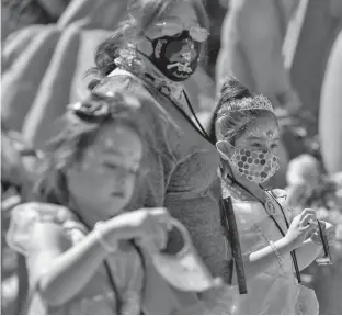  ?? REUTERS ?? A family wears face masks as they attend Knott’s Berry Farm’s Halloween-themed attraction with social distancing during the outbreak of the coronaviru­s disease in Buena Park, Cal.