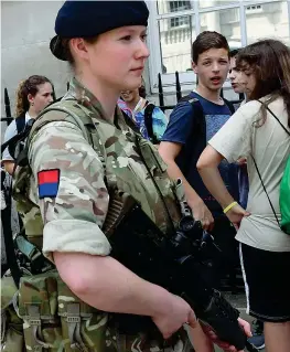  ??  ?? In armi Soldati britannici pattuglian­o il centro di Londra, sotto lo sguardo dei passanti: nel Regno Unito solo in tempi eccezional­i i militari scendono in strada