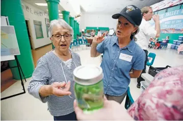  ?? PHOTOS BY LUIS SÁNCHEZ SATURNO/THE NEW MEXICAN ?? Santa Fe County Utilities Department Aamodt Project Manager Sandra Ely, right, explains to Avelina Montoya of Cuyamungue that a pint of water will not be enough to test her well. Ely, who was helping well owners at Friday’s Pojoaque Basin Water Fair at...